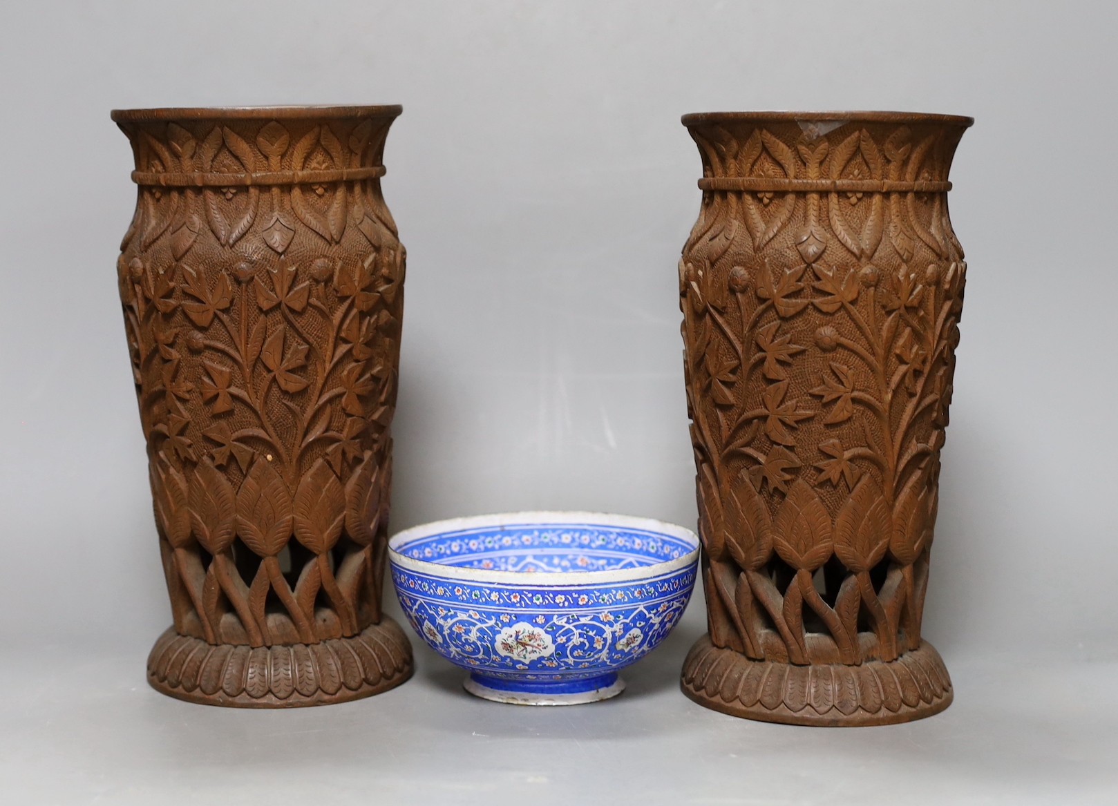 A pair of Indian carved wood vases, 22.5cm high, and a Persian blue enamel bowl (3)